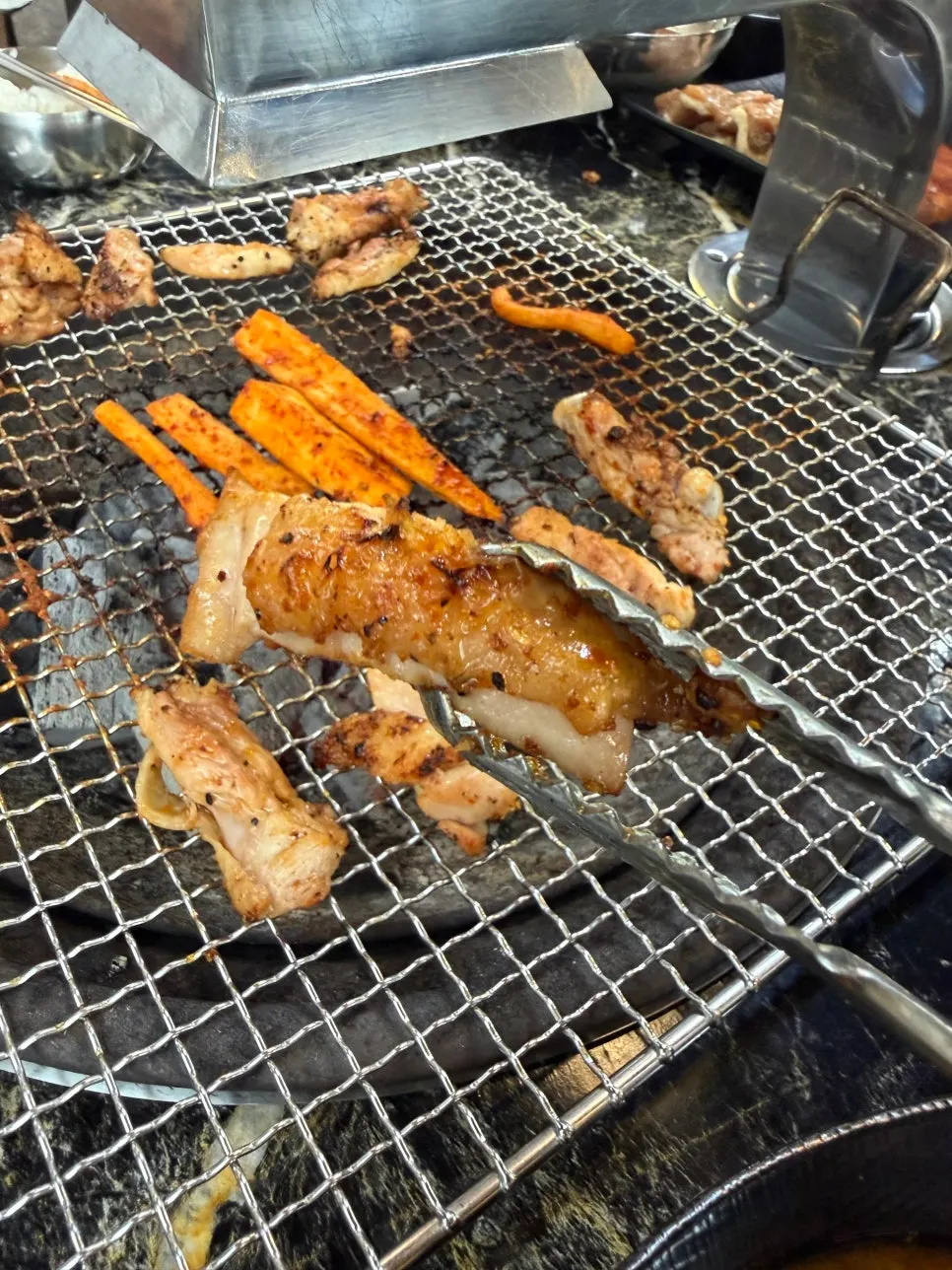 Close-up of salt dakgalbi cooking over charcoal