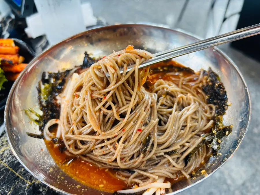 Table with charcoal-grilled dakgalbi and makguksu eaten together