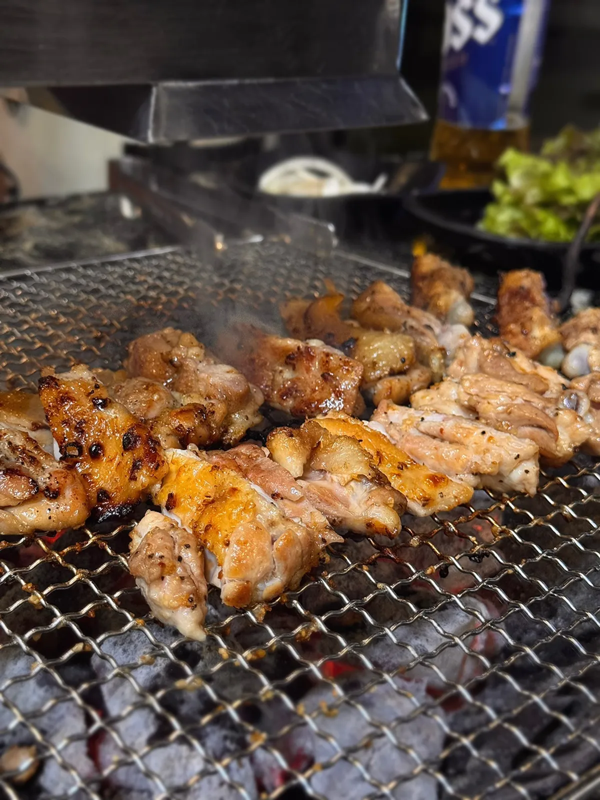 Close-up of dakgalbi grilling over charcoal
