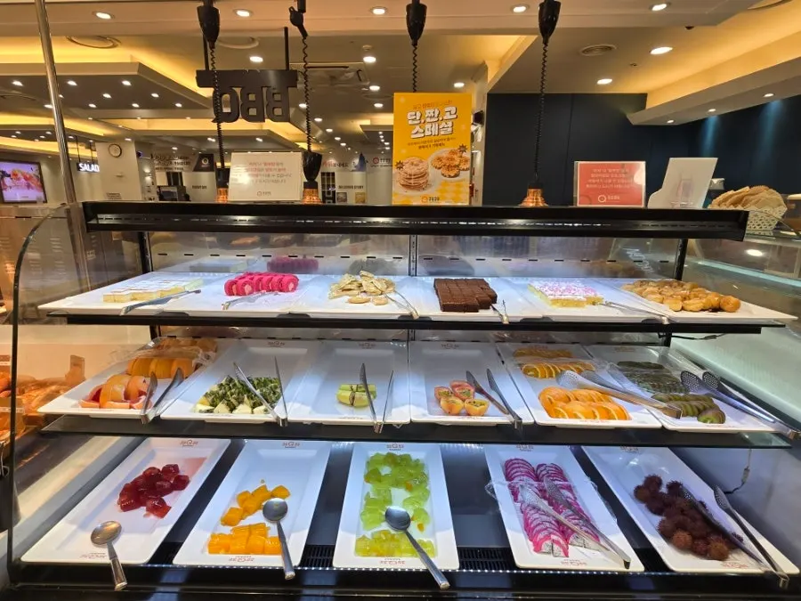 Dessert stand with cake, fruit, and pudding