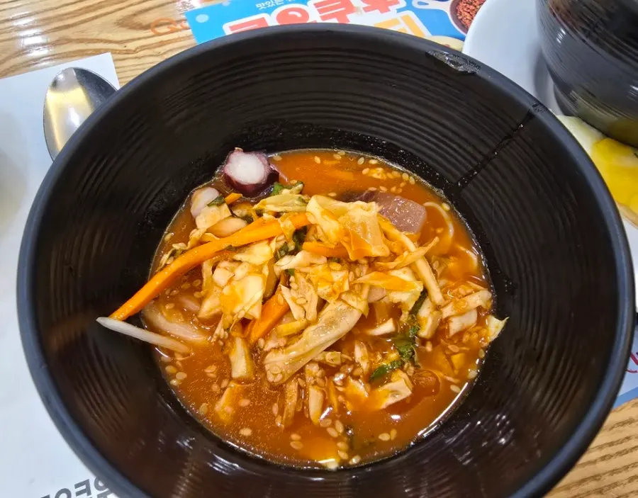 A bowl of mulhoe broth with vegetables and raw fish