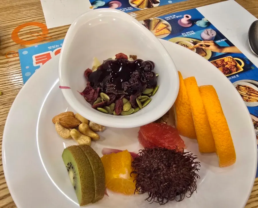 A dessert plate with nut yogurt, cake, and fruit