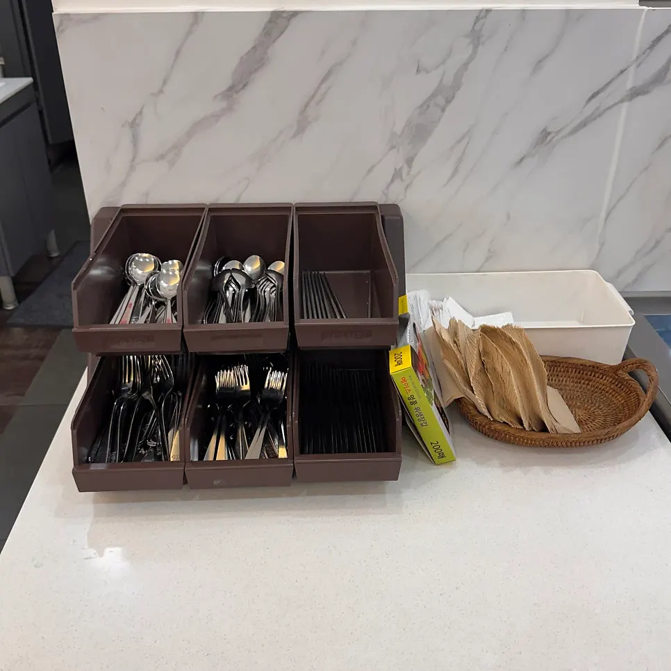 Utensils and hygiene gloves stand next to the buffet corner