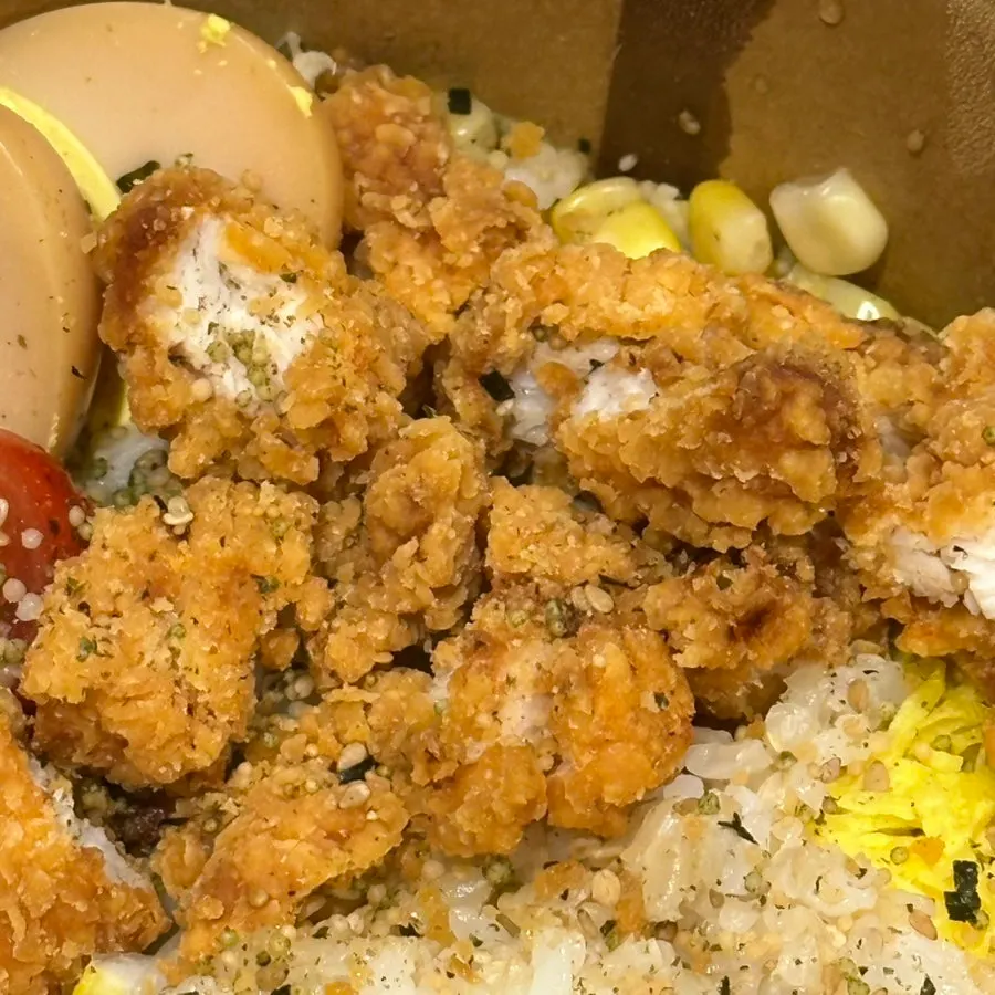 Chicken tenders on top of brown rice and lettuce