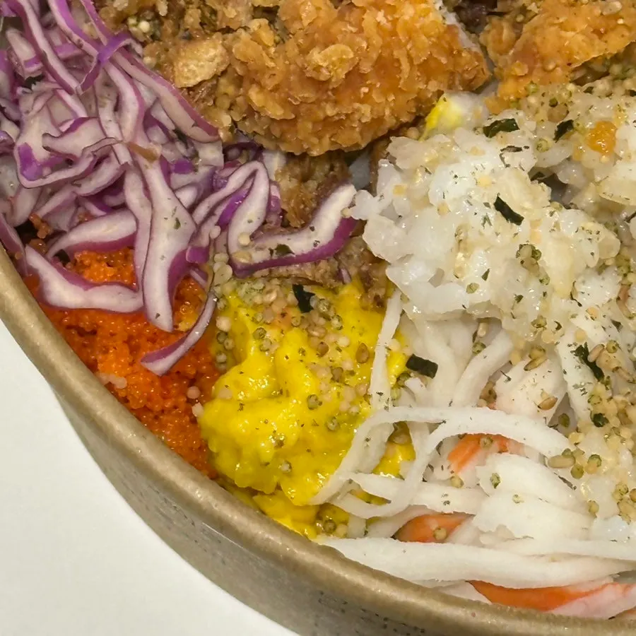 A bowl of chicken tender poke packed with ingredients