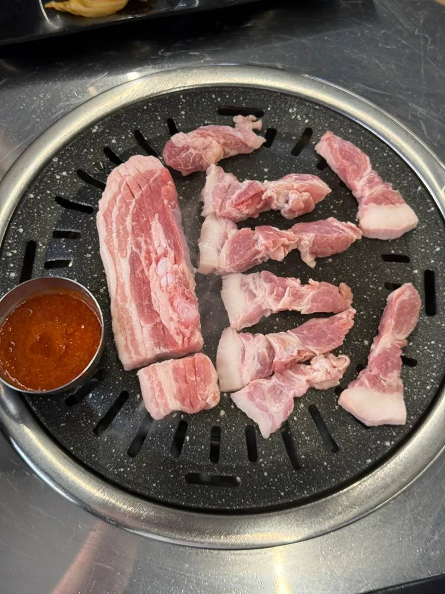 Samgyeopsal and cheonsang mokssal placed on the grill