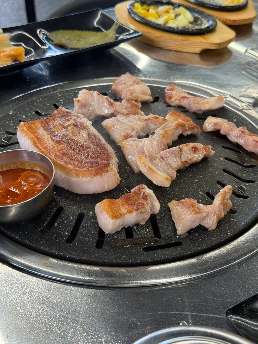 Close-up of pork cooking over a strong flame