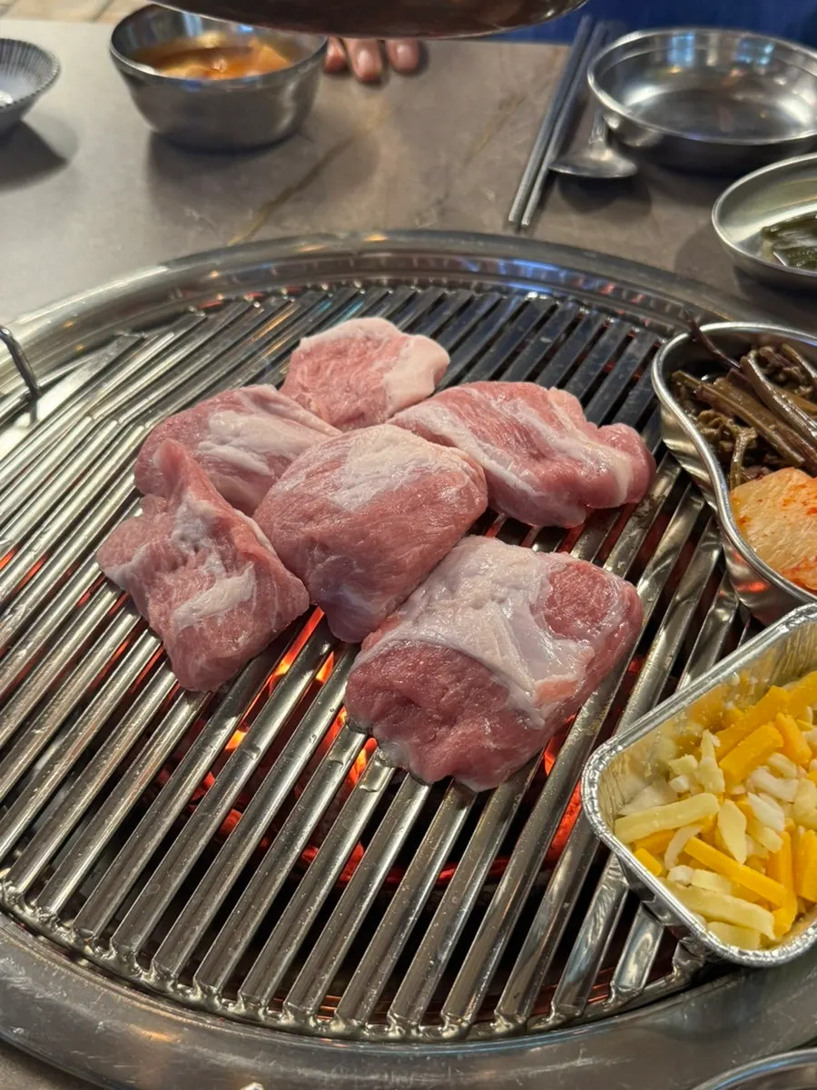 Staff member placing meat on the grill