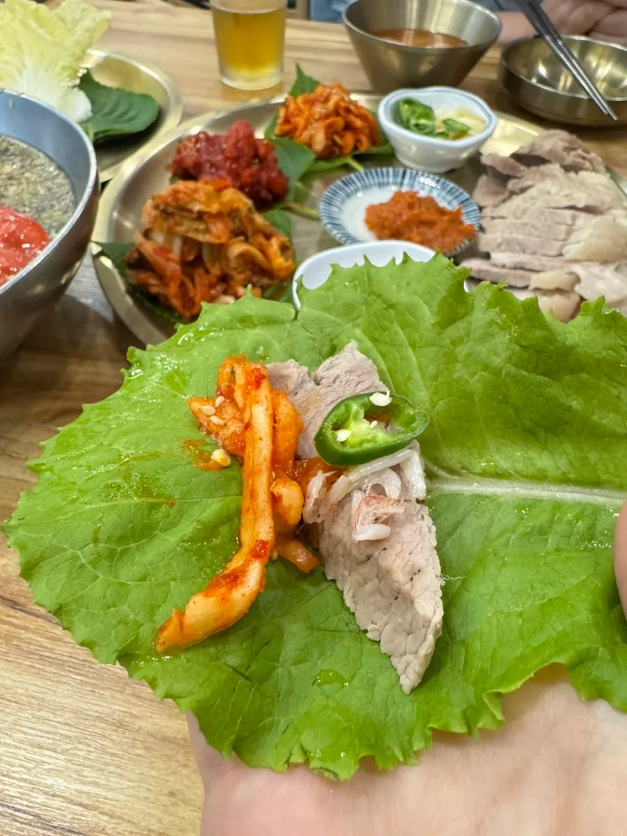 무김치에 보쌈을 올려 싼 쌈 한 입