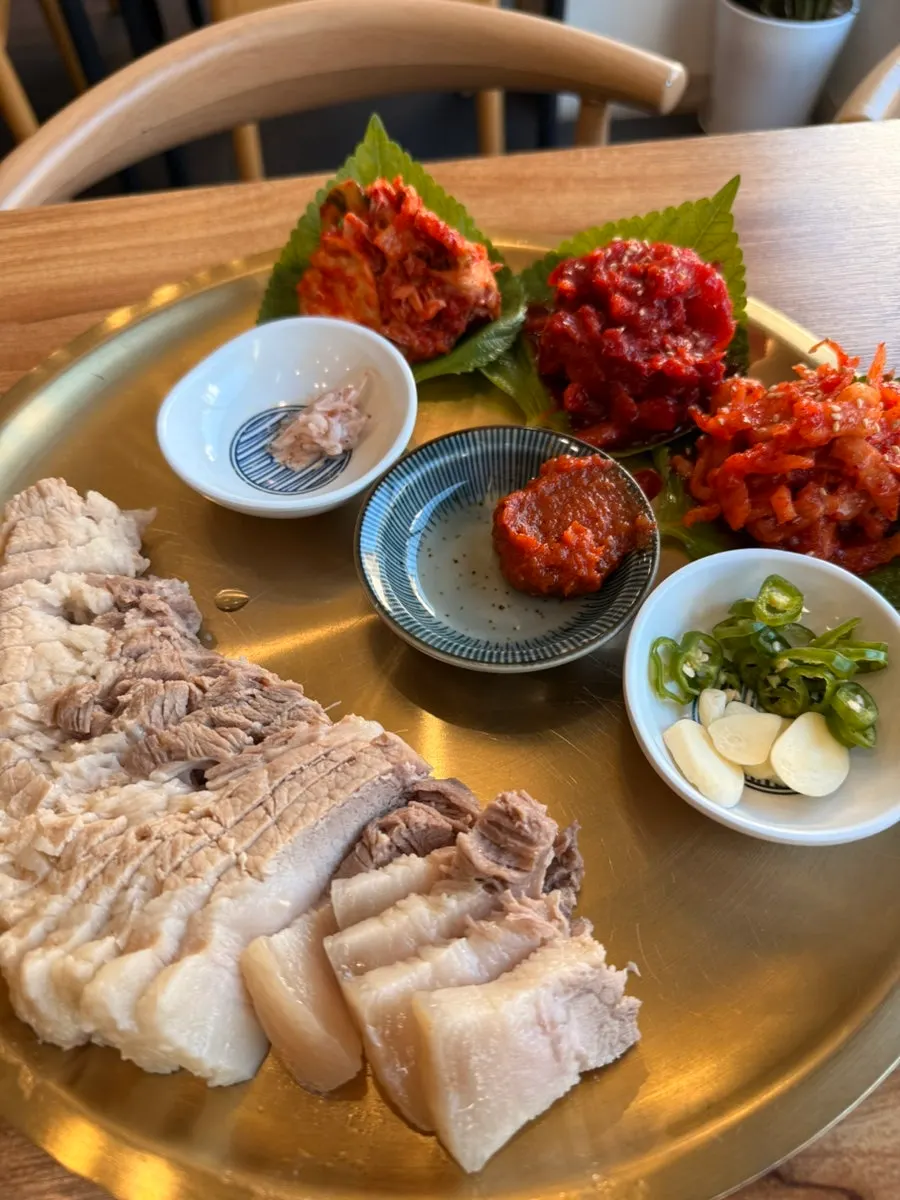 Wrapping bossam pork in a lettuce leaf