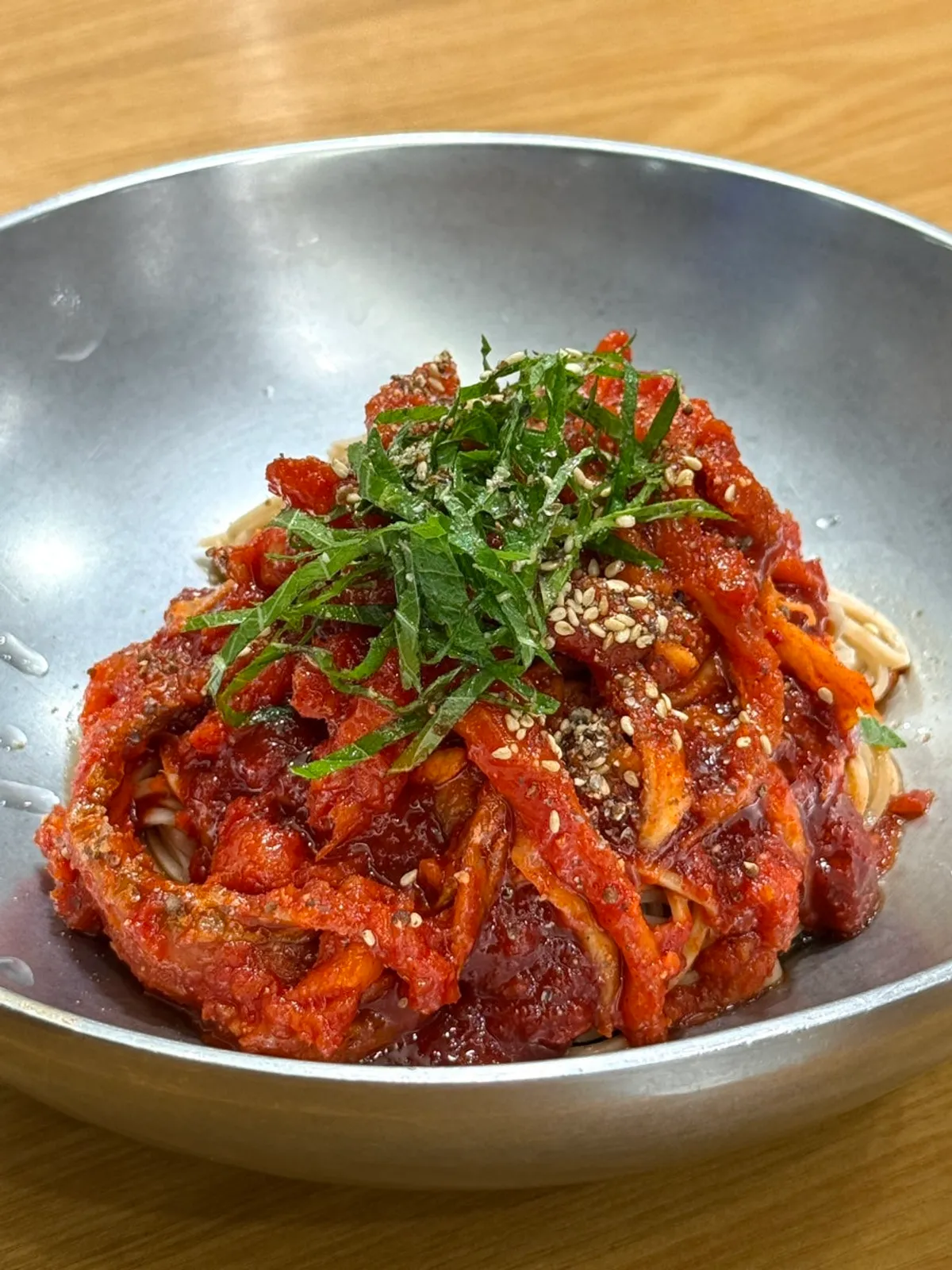 A bowl of pollock hoe makguksu topped with seasoned raw pollock