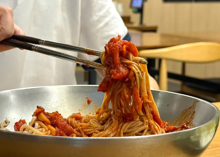 拌上醬料夾起一口的明太魚膾蕎麥冷麵