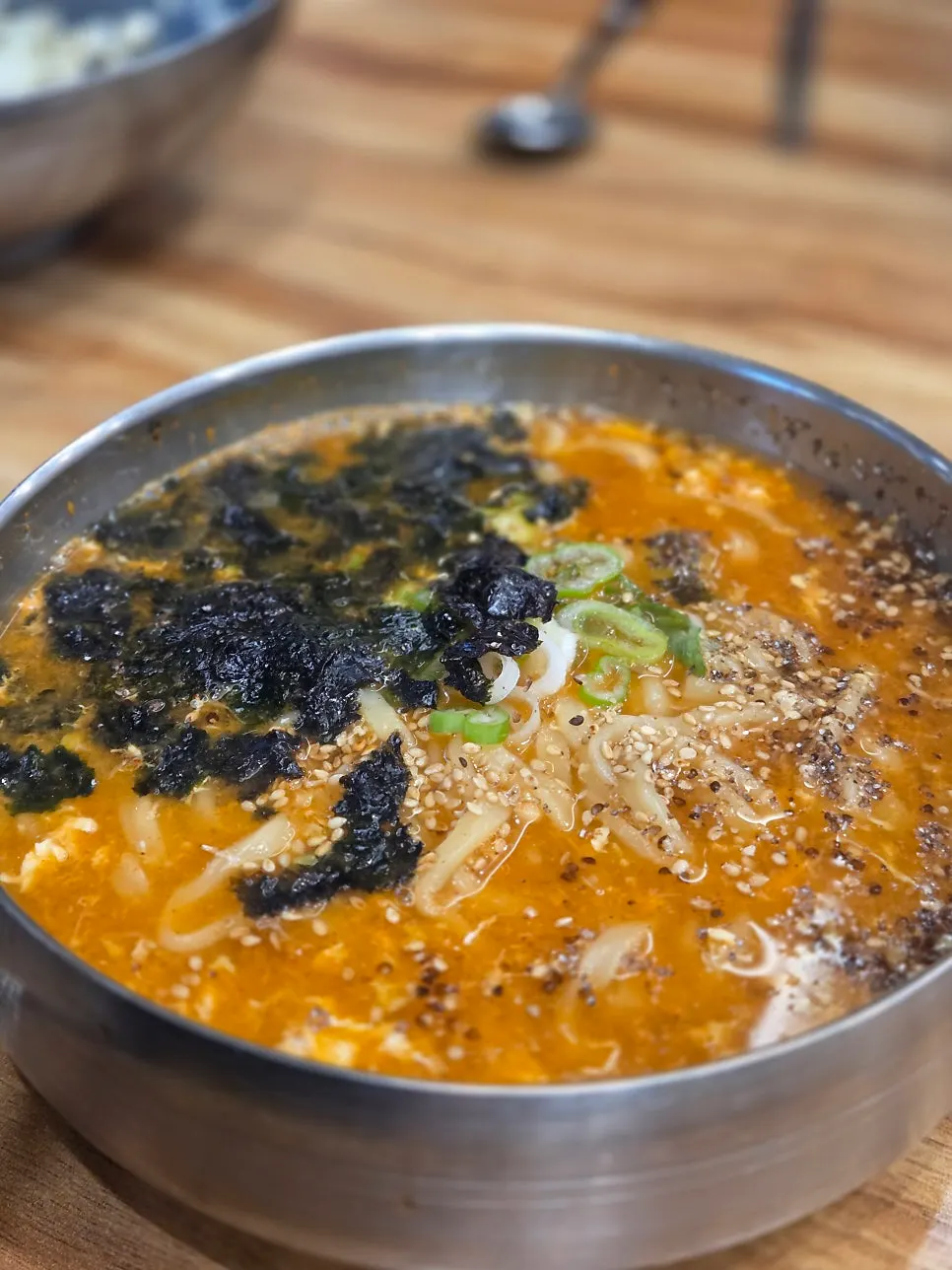 Jang-kalguksu topped with egg, sesame, and gim flakes