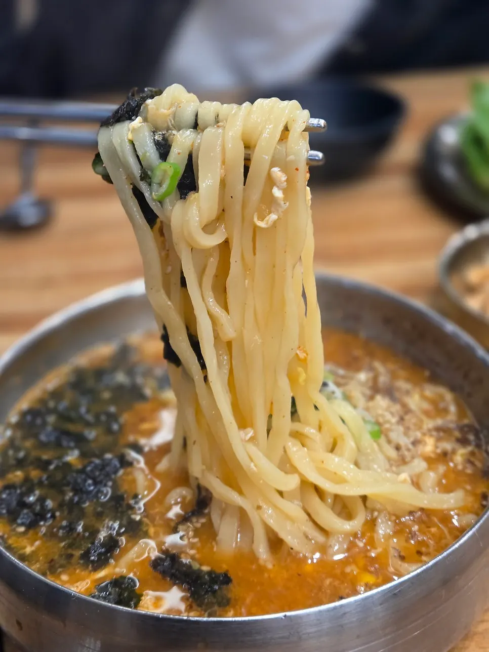 Lifting up a forkful of homemade jang-kalguksu noodles