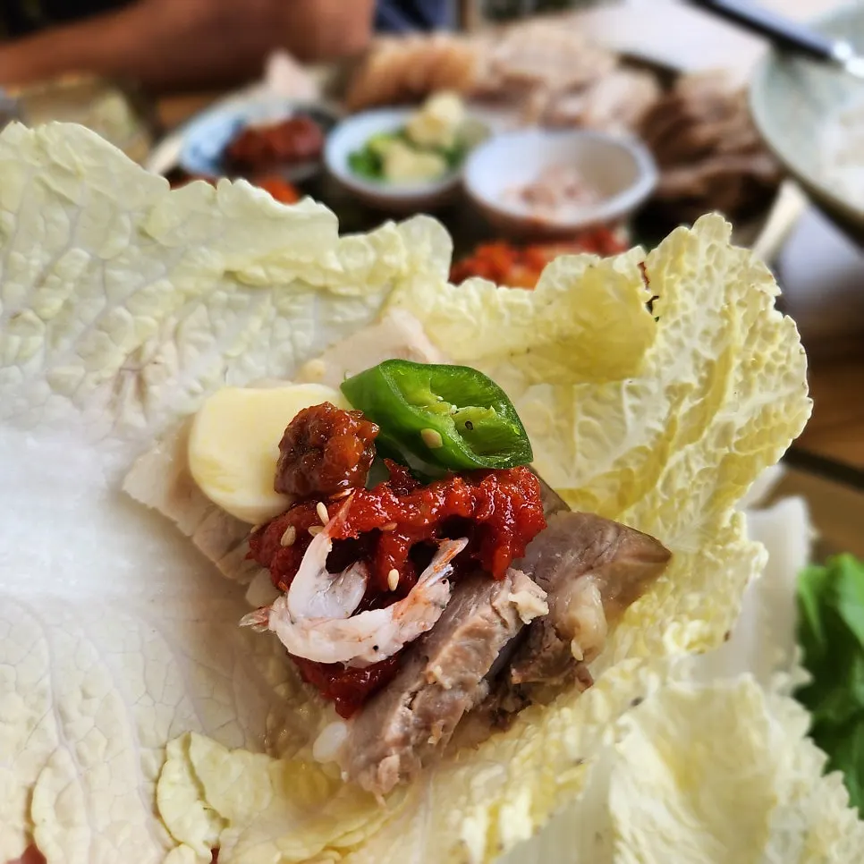 A bite of bossam combined with various side dishes