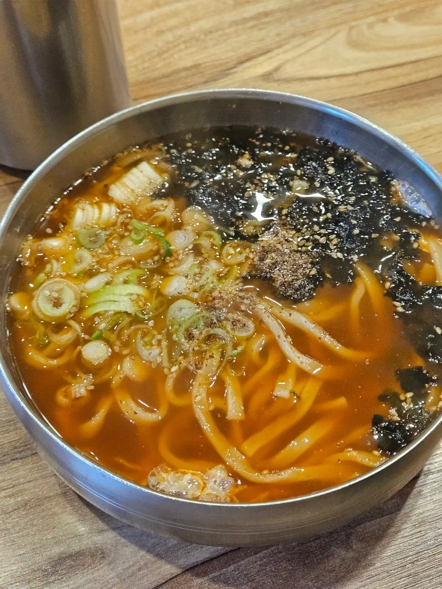 A bowl of soba and bossam set on the table