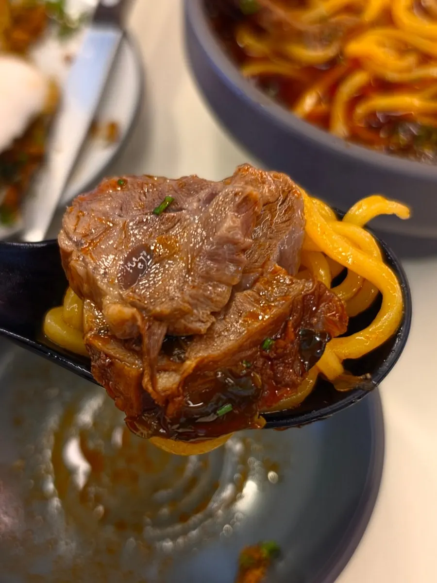 Beef noodle soup topped with noodles and beef