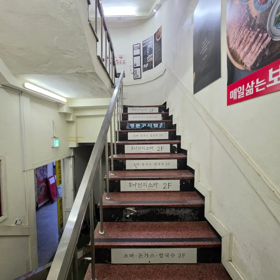 Cartel con el menú de Nagwon-ui Soba en la entrada del edificio
