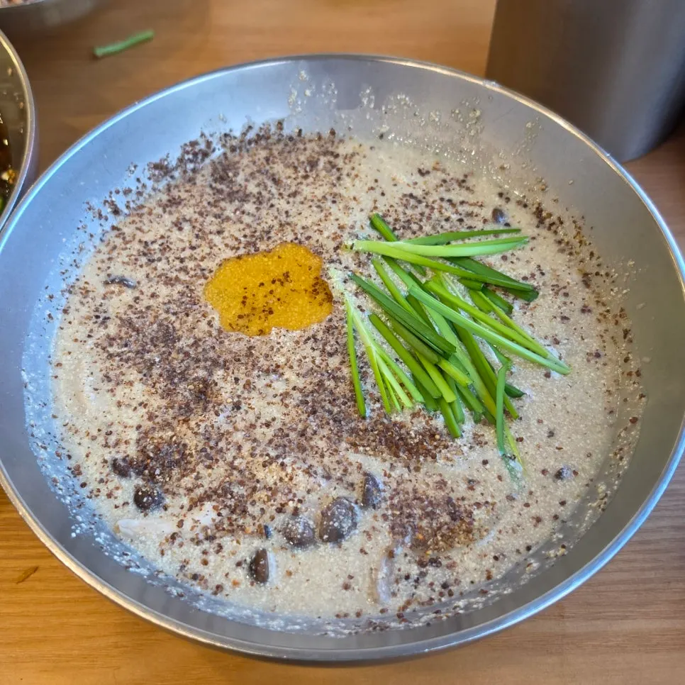 Sujebi de sésamo perilla con caldo de hueso, con abundante perilla espolvoreada