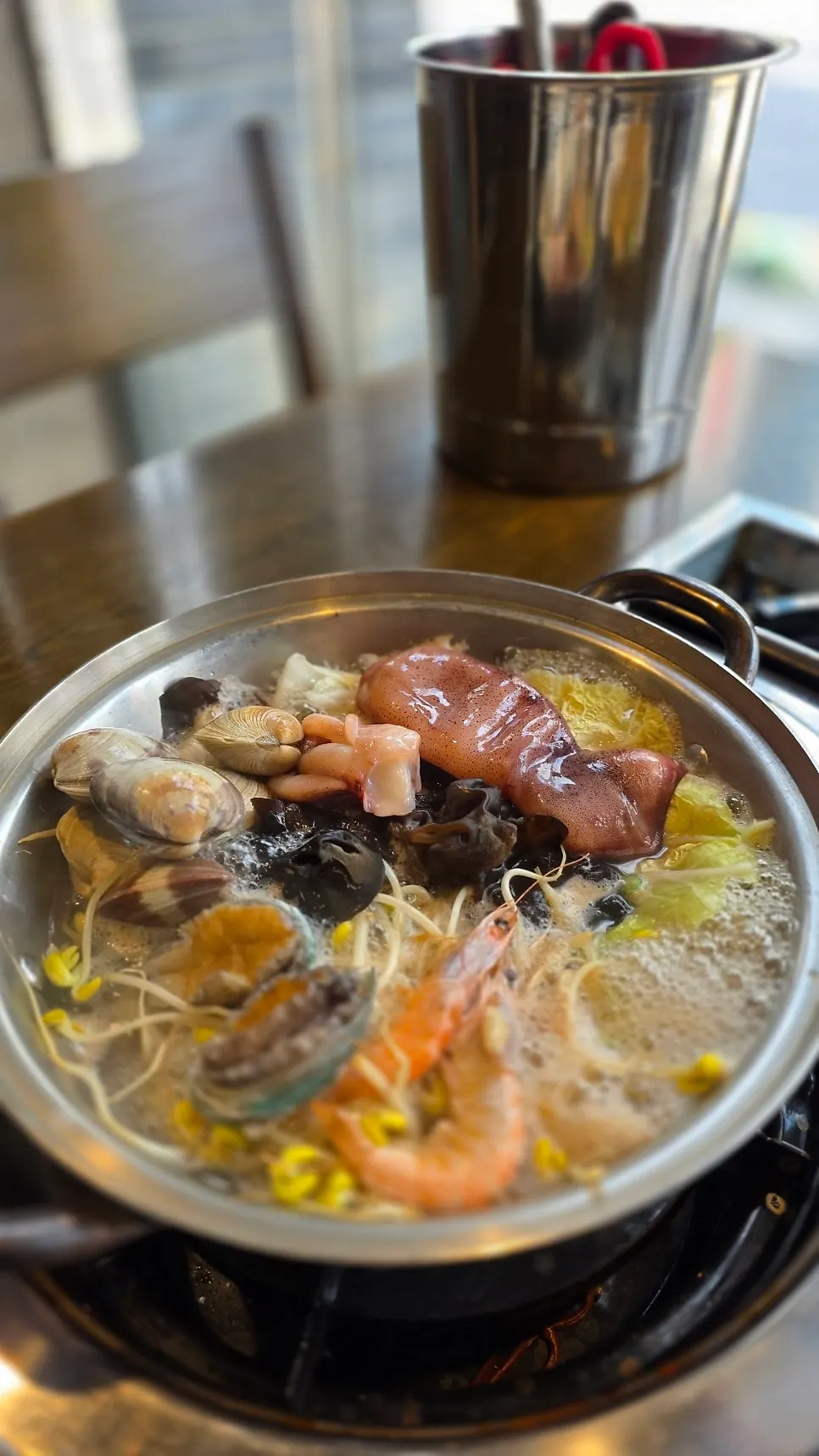Seafood kalguksu pot topped with squid, clams and abalone