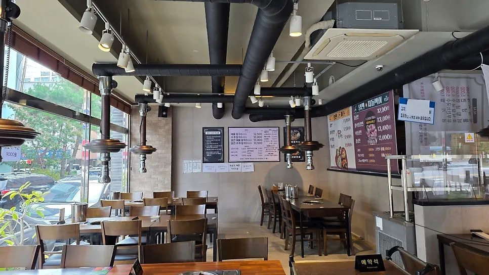 Interior with rows of 4-person tables each fitted with a burner