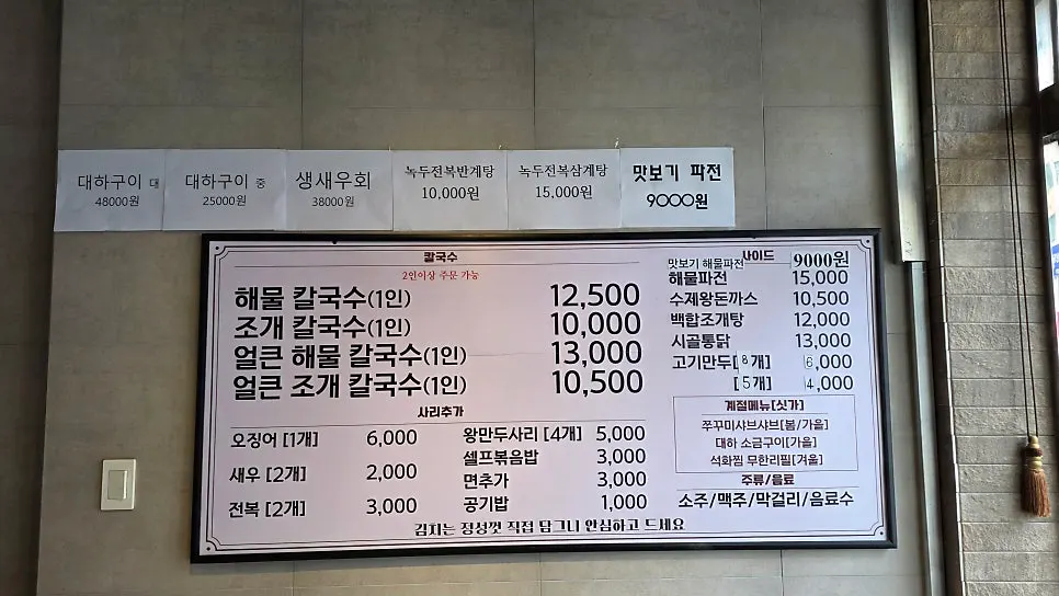 Menu board listing seafood kalguksu prices