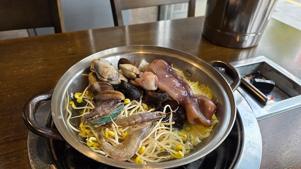 Menu board listing seafood pajeon and side dishes