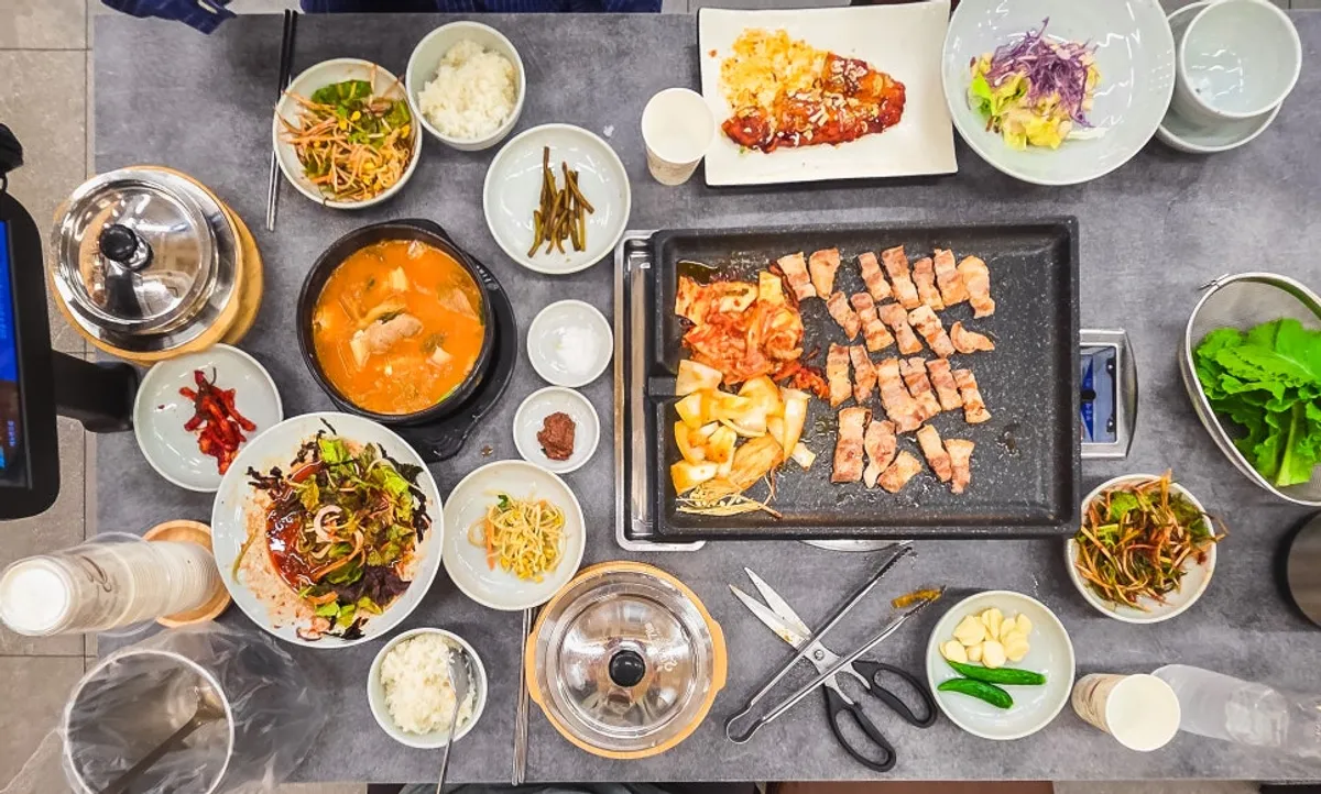 Table spread of raw pork belly and galbi kimchi stew at Chung-sil Hoegwan
