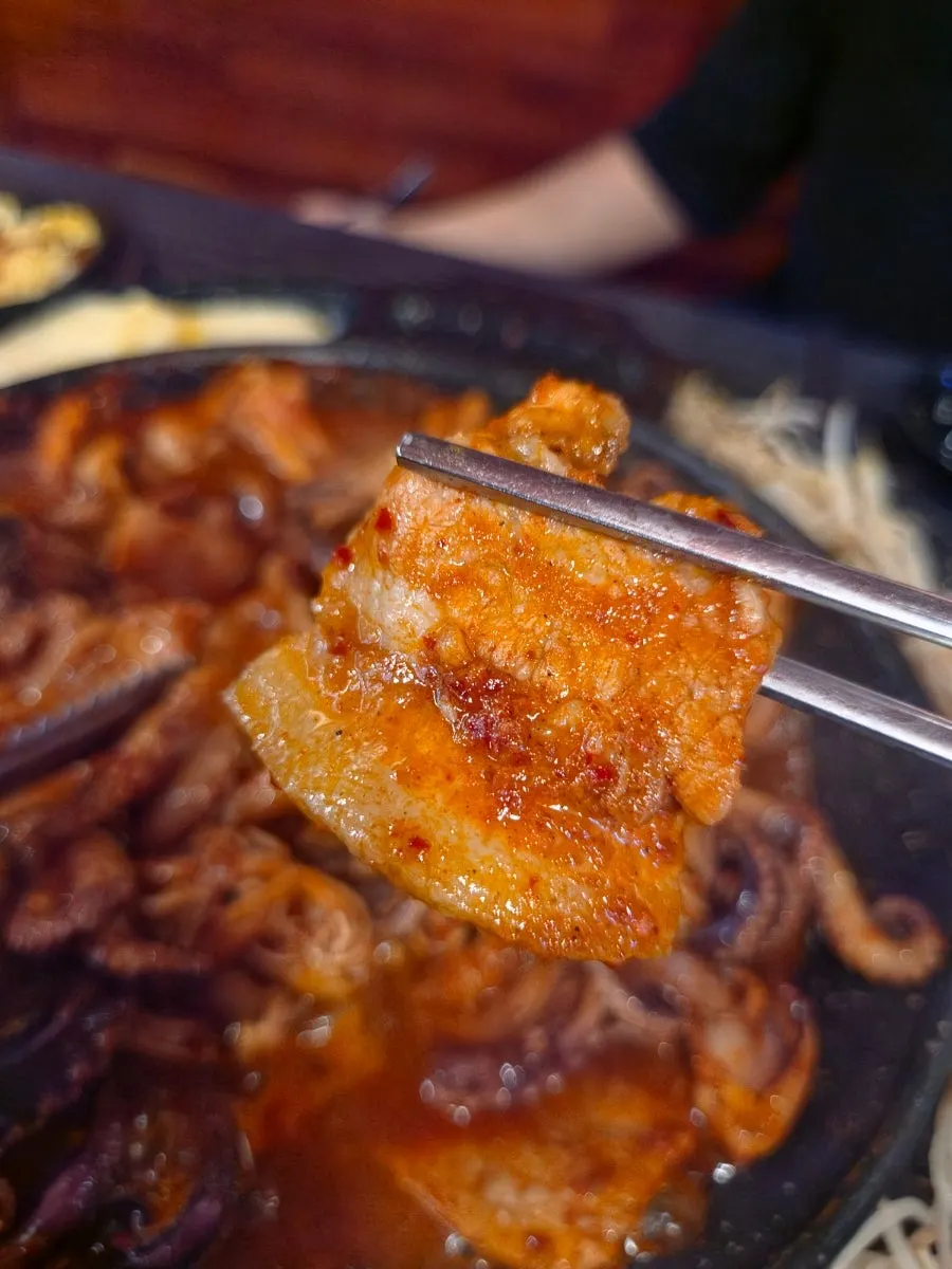 A piece of octopus topped with cheese and sweet potato mousse