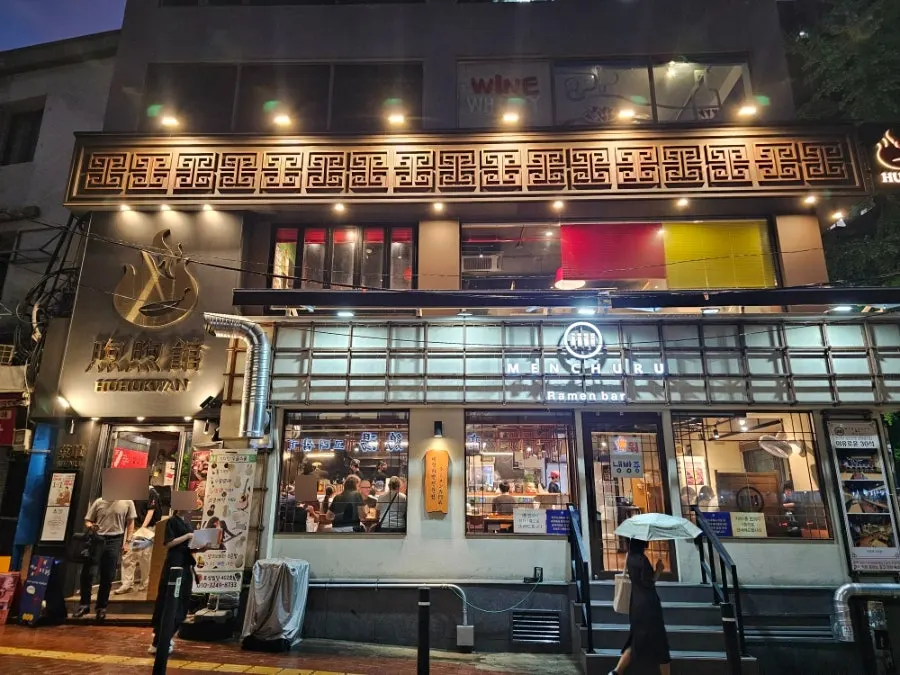 Huhugwan exterior and sign on a rainy evening