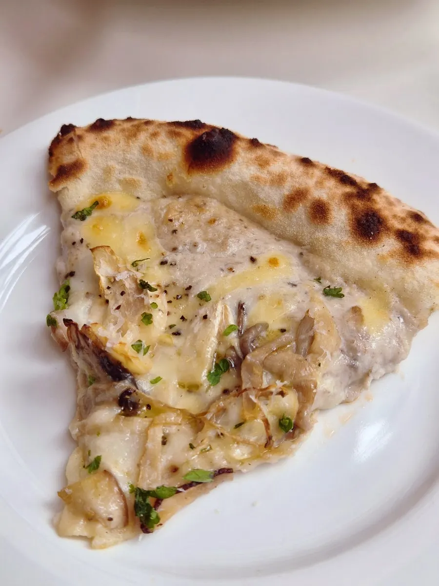 Plate of Quattro Fungi Pizza partway through eating
