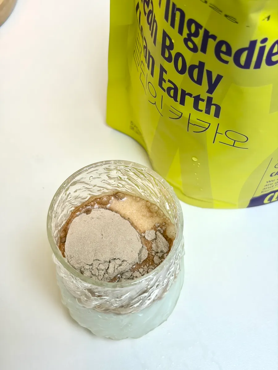 Cup with two spoonfuls of protein powder added to milk