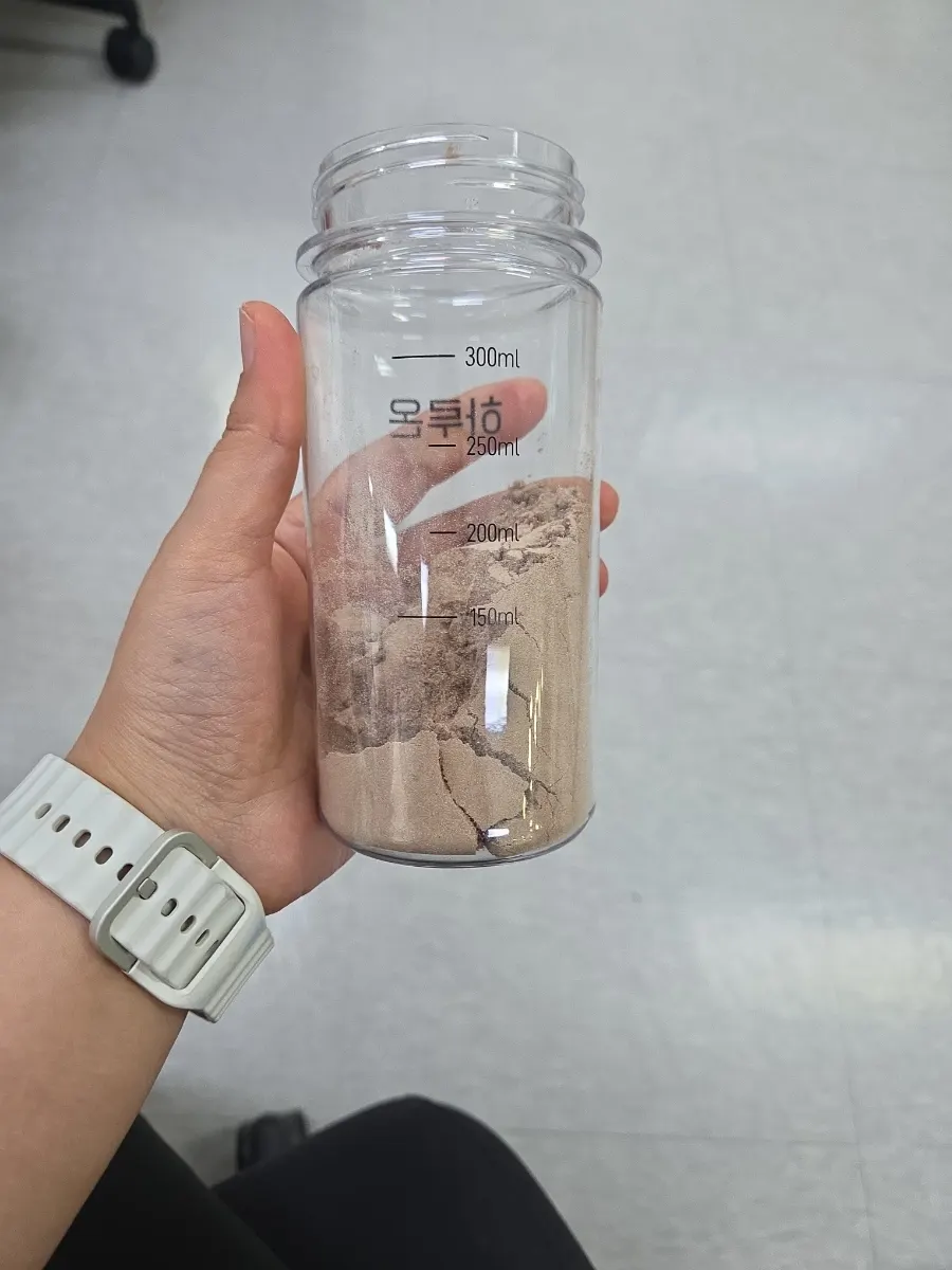 Opened pouch showing fine cacao-colored protein powder