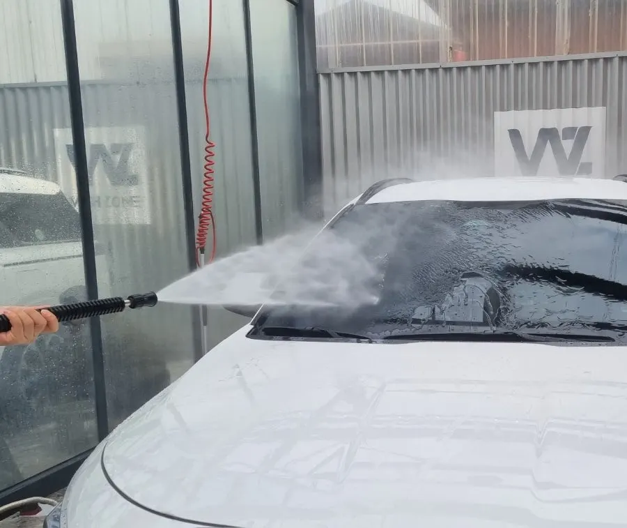 Spreading oil-film remover across a windshield with a work towel