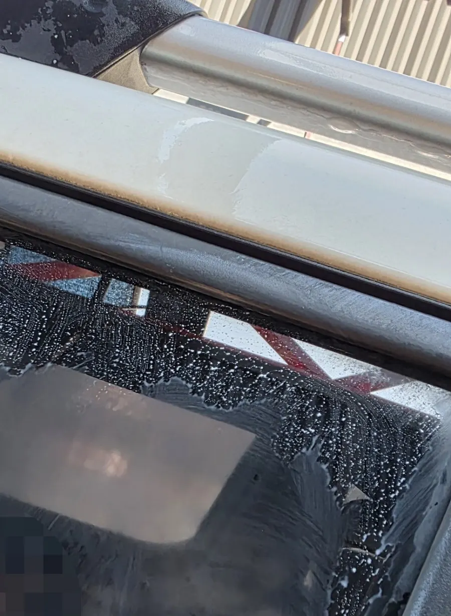 Applying oil film remover with a microfiber towel while wiping the windshield