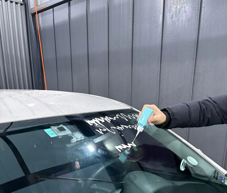 Process of cleaning a car window with AutoGrooming oil film remover