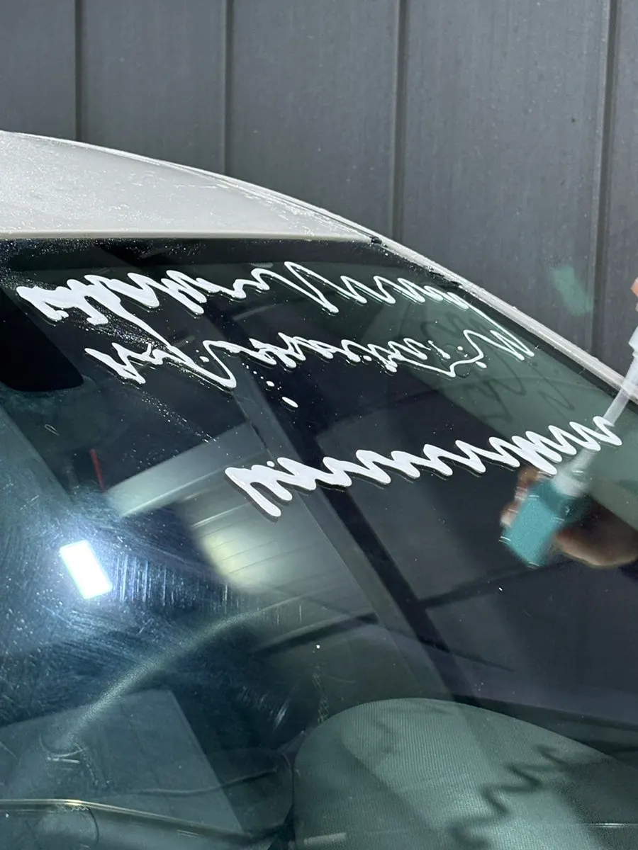 Car glass surface after applying and rubbing in oil film remover
