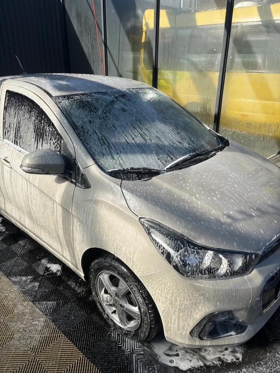 Car glass surface with oily-film smudges and haze