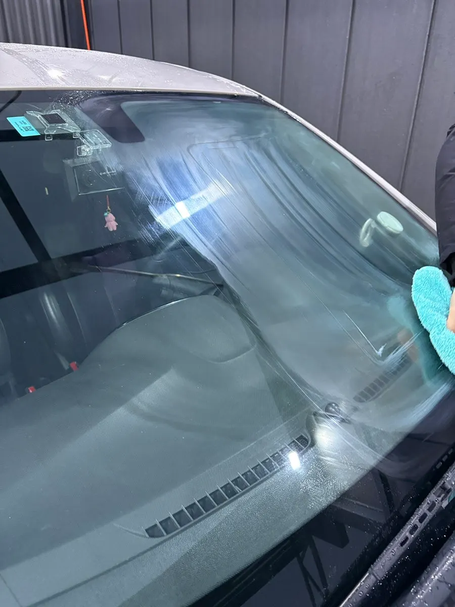 Car window checked for clarity after oil-film removal