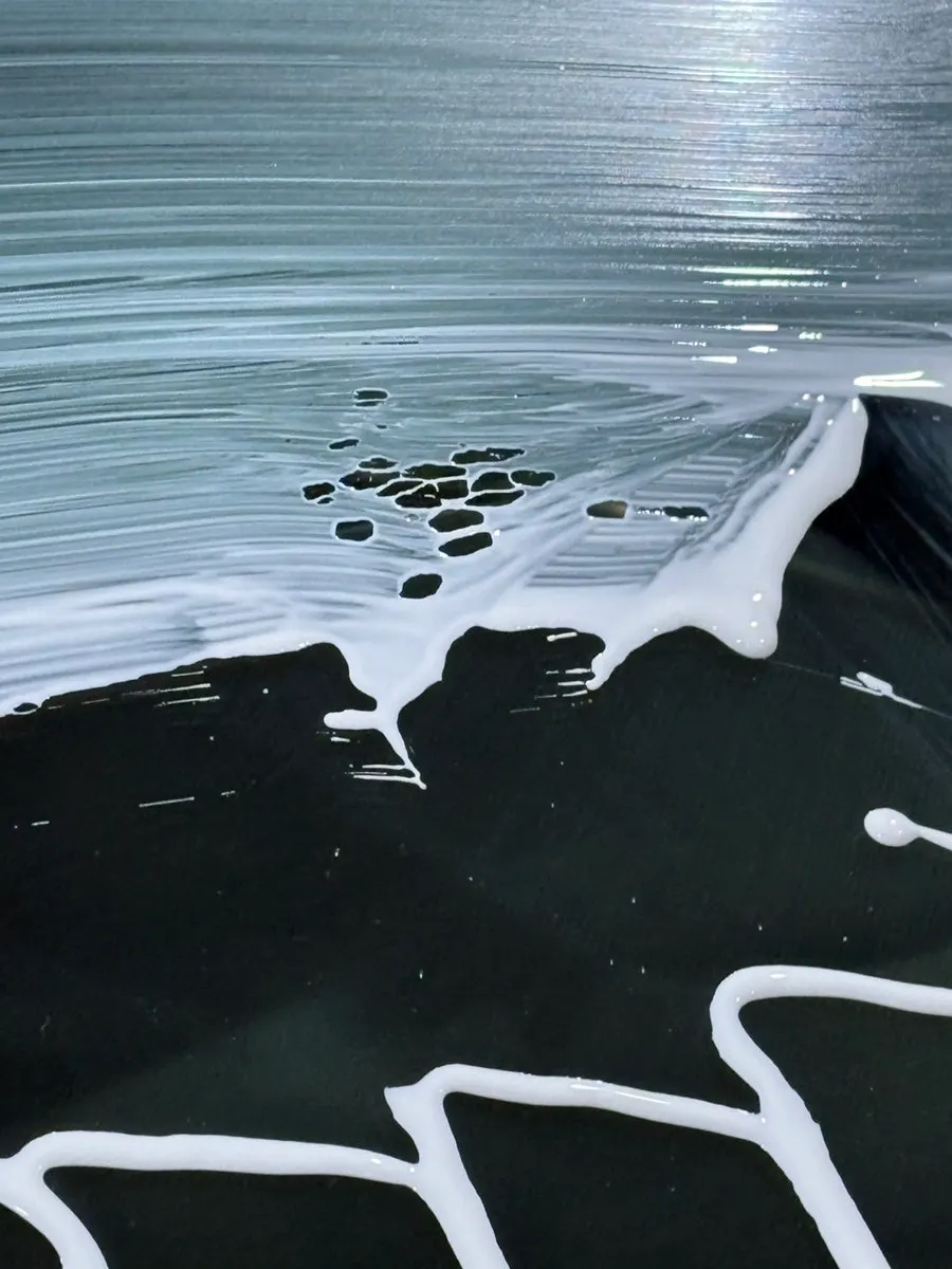 Applying oil film remover to the windshield with a towel