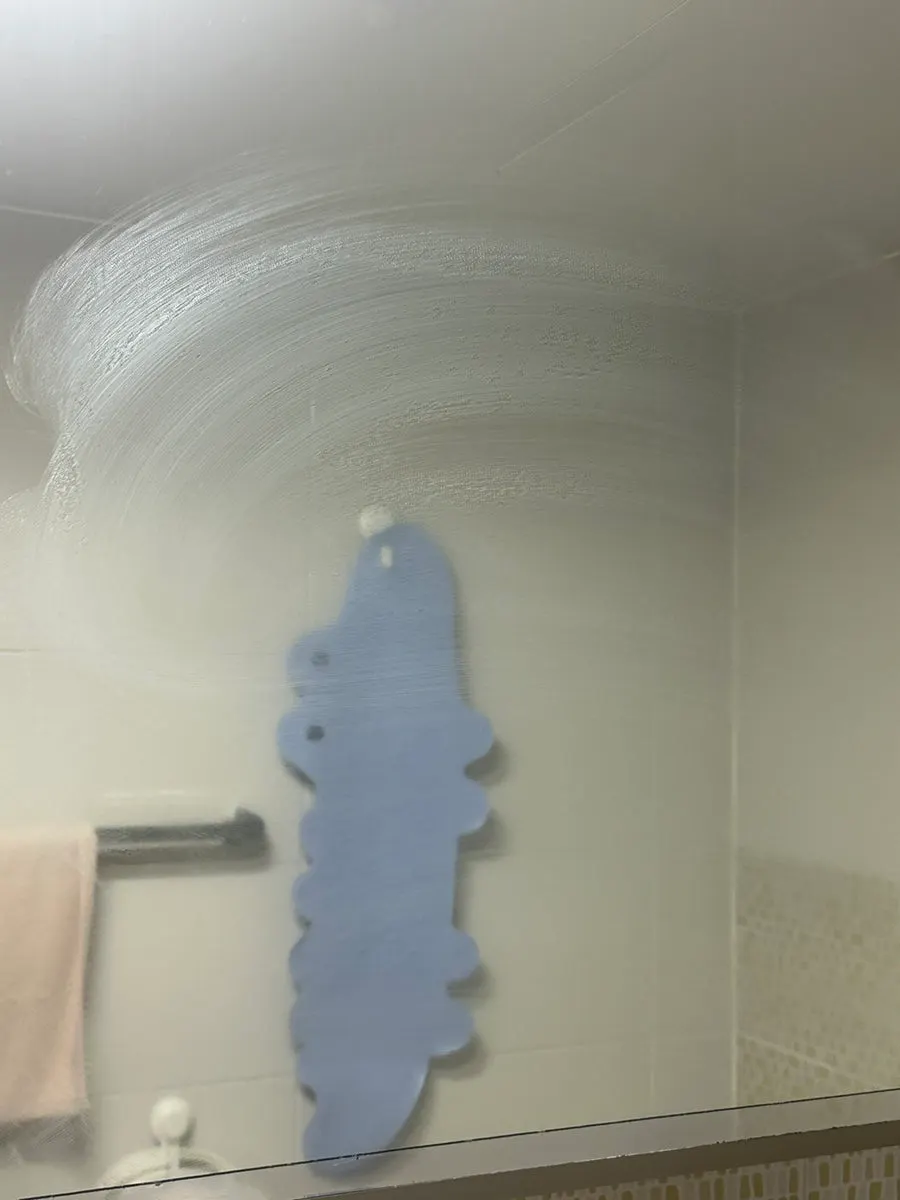 Cleaning a bathroom glass mirror with white marks