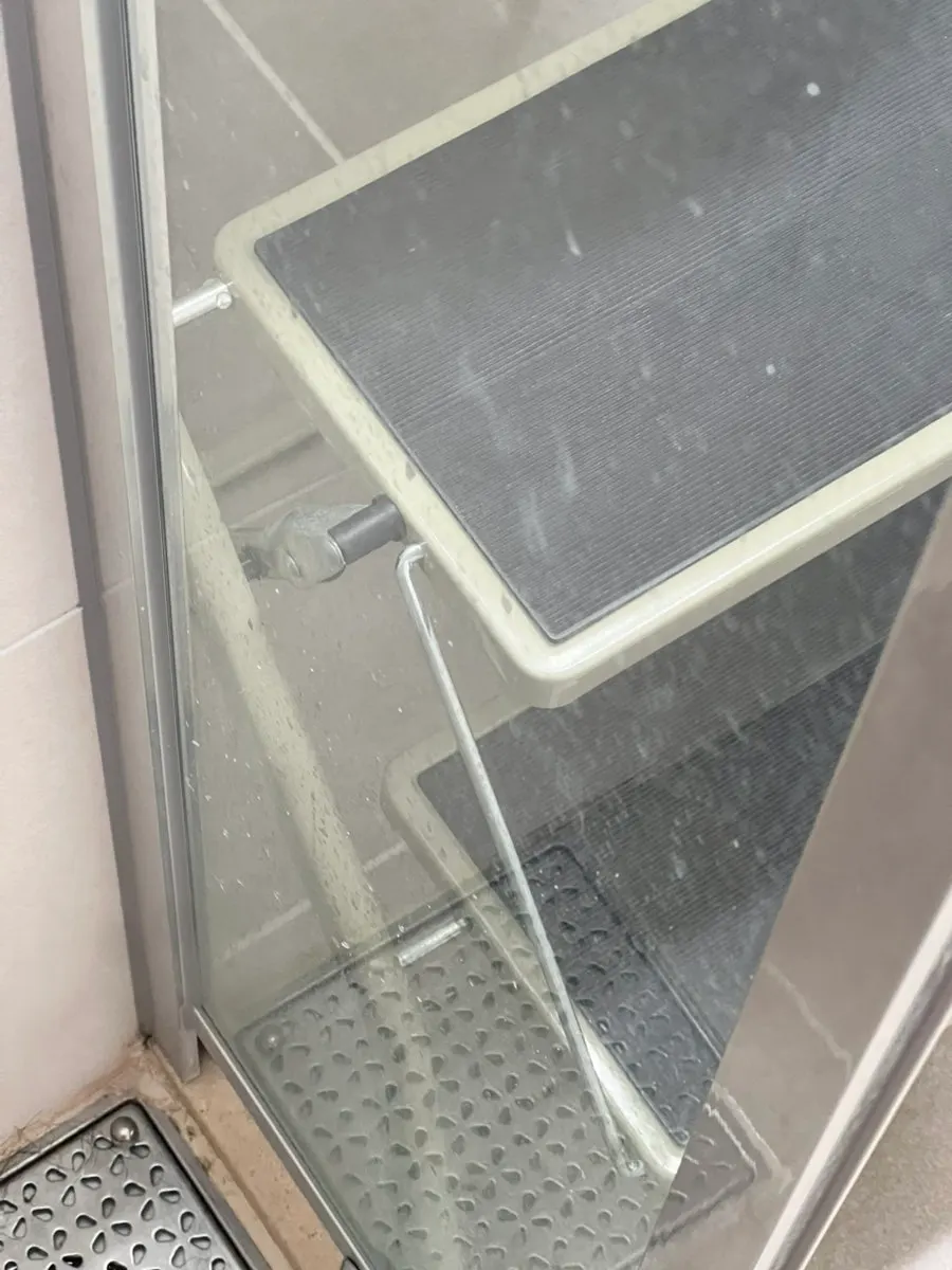 Shower-booth glass with hardened shampoo foam marks