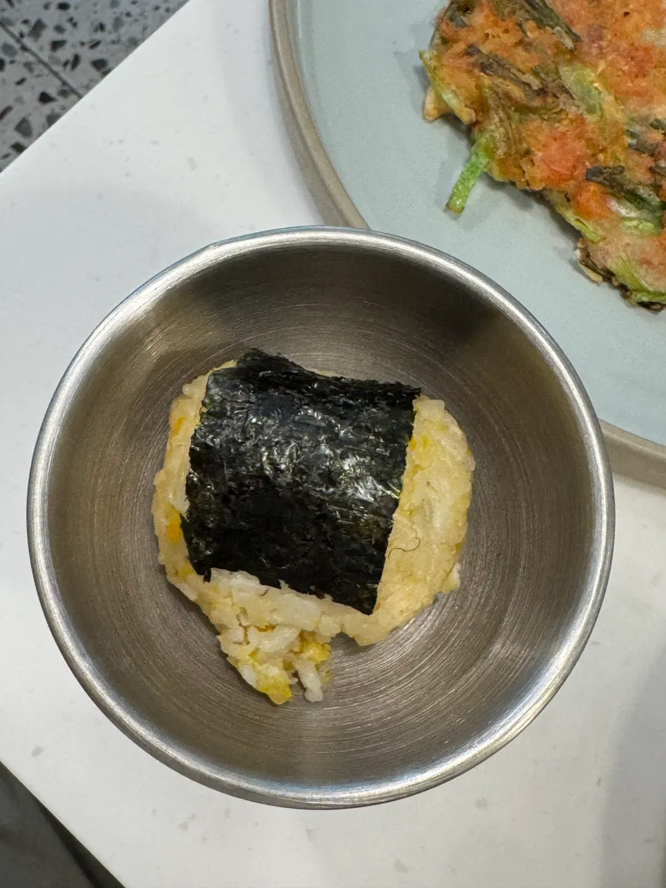 Complimentary egg rice ball served in a metal bowl