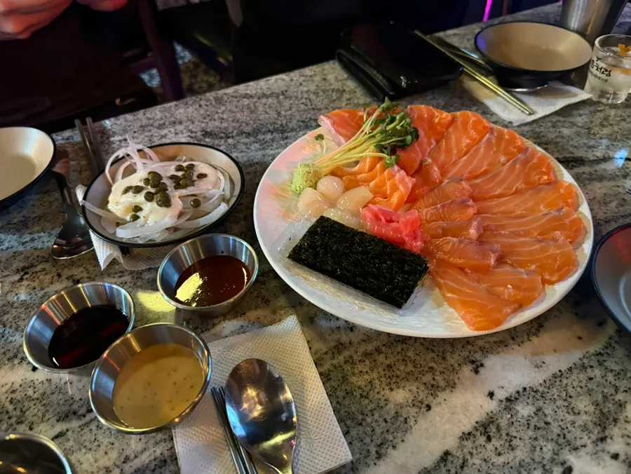 Salmon sashimi served with onion and fresh wasabi