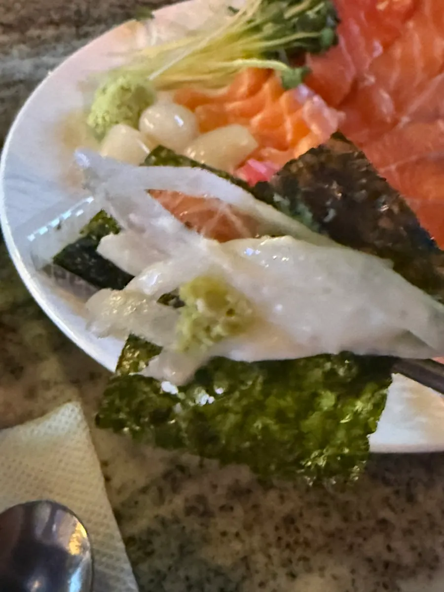 A piece of salmon placed on a sheet of gim