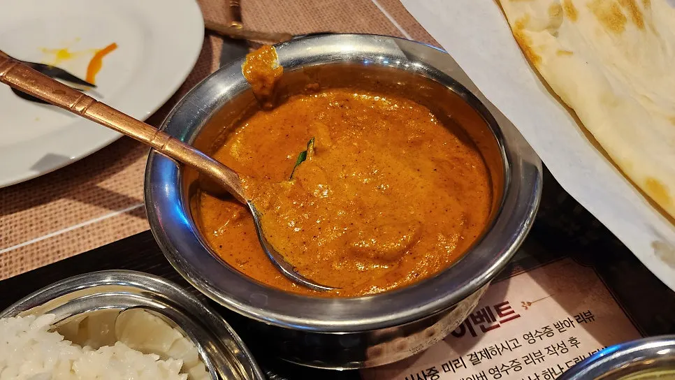 Dipping naan into chicken tikka masala