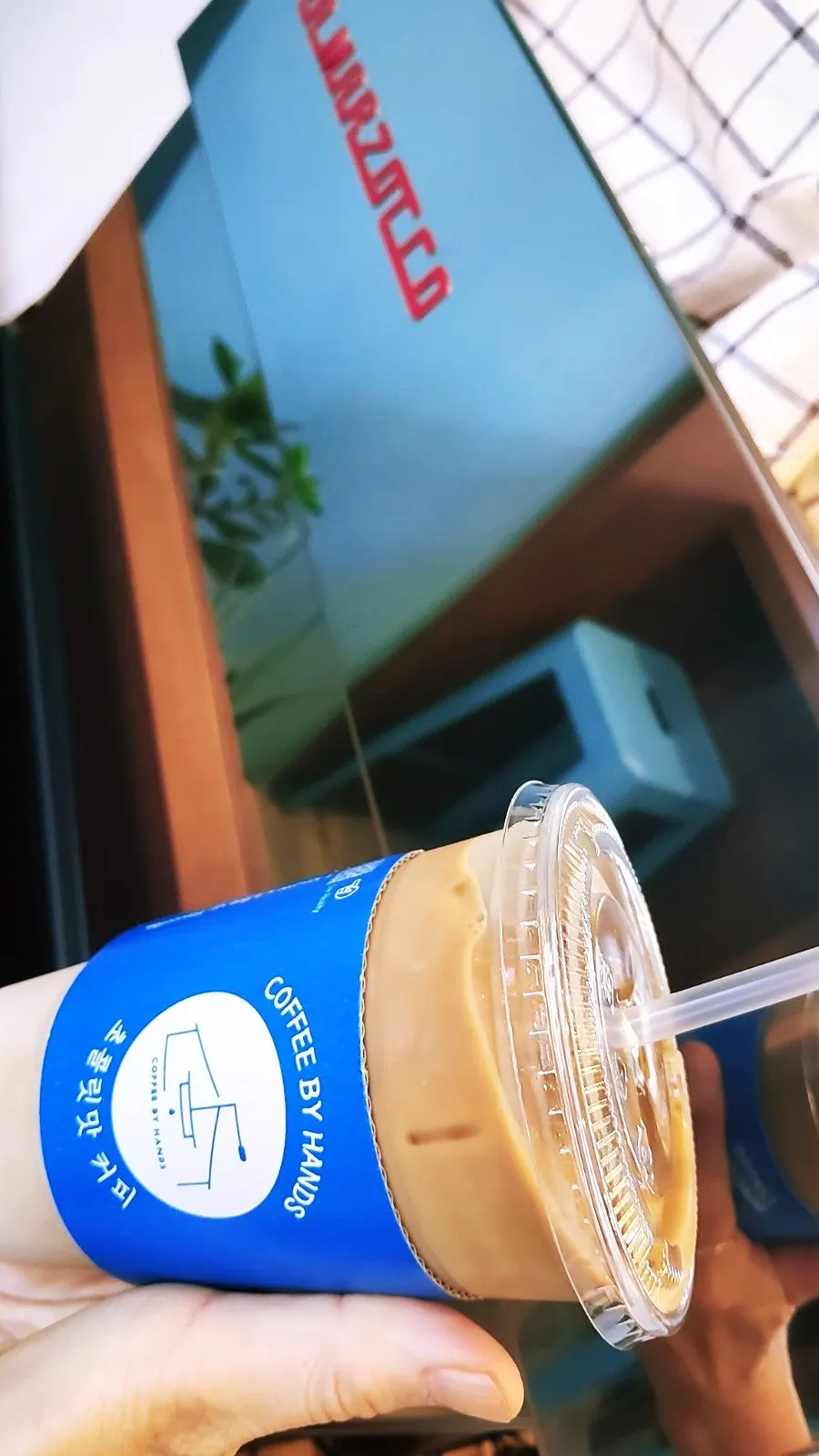 Bottle latte photographed in front of the café