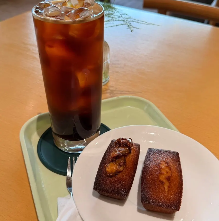 Iced americano and two financiers on a table