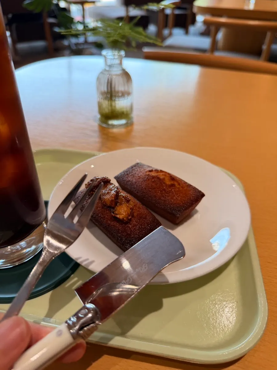 Financiers plated alongside an iced americano