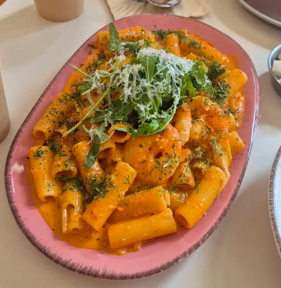 A plate of shrimp rosé pasta topped with shrimp